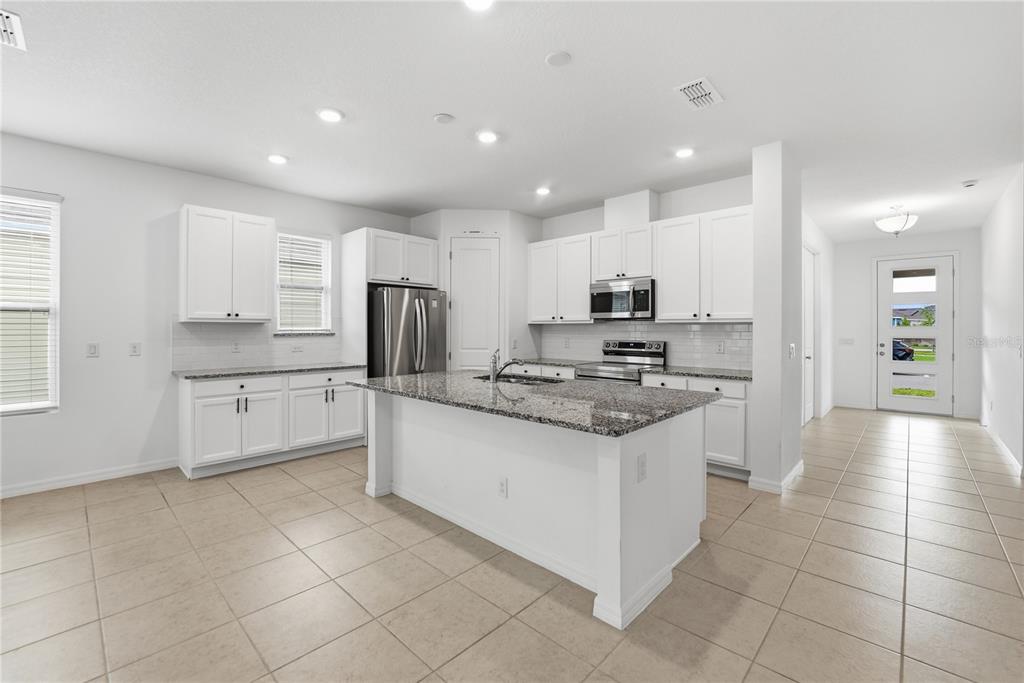 6550 Barnstorm Way St. Cloud, FL 34771 - Photo 14 of 35 a large kitchen with stainless steel appliances and a sink