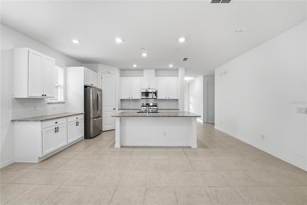 6550 Barnstorm Way St. Cloud, FL 34771 - Photo 15 of 35 a large kitchen with cabinets and stainless steel appliances
