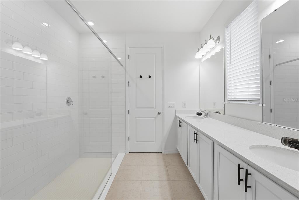 6550 Barnstorm Way St. Cloud, FL 34771 - Photo 23 of 35 a bathroom with a double vanity sink and mirror with shower