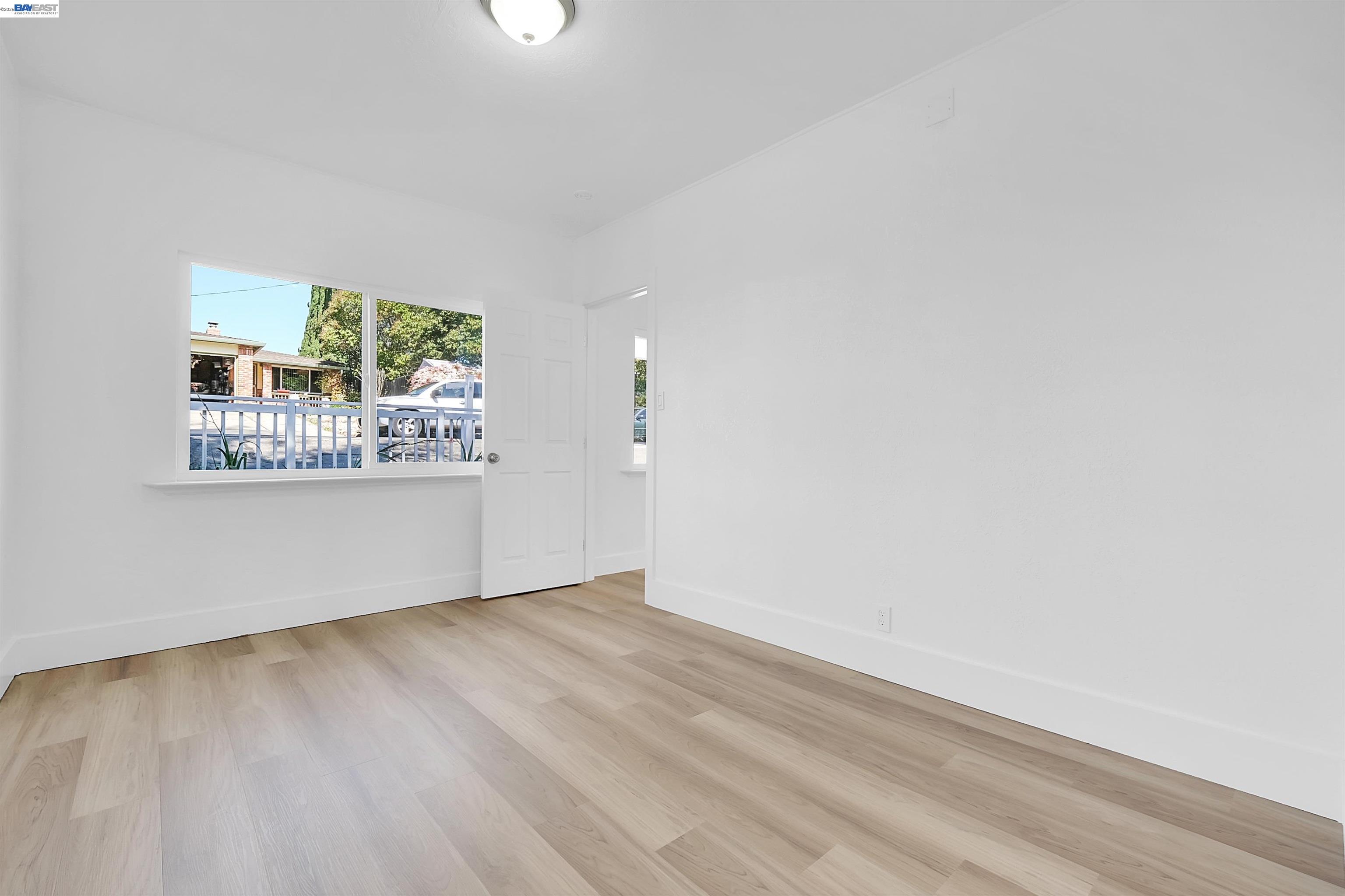 1467 Clay Street Hayward, CA 94541 - Photo 12 of 28 an empty room with wooden floor and windows