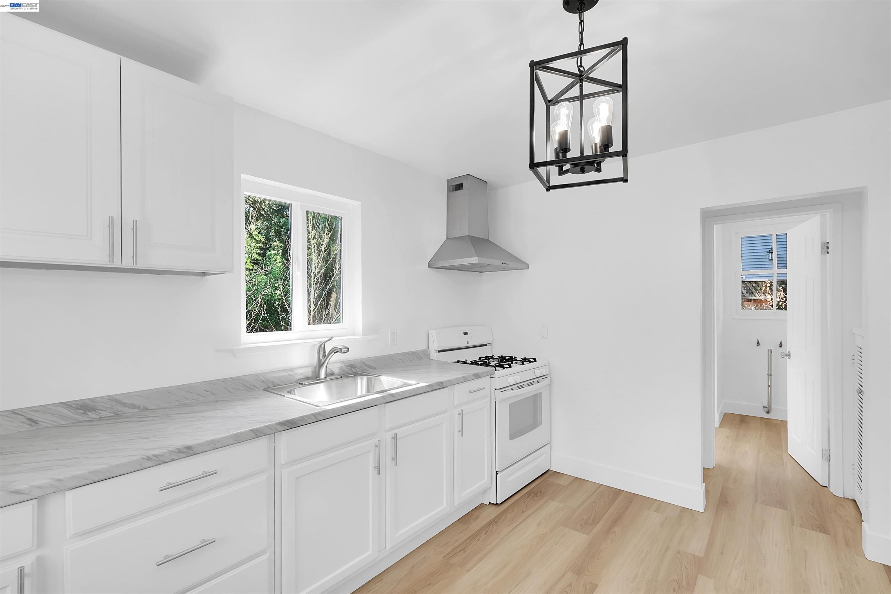1467 Clay Street Hayward, CA 94541 - Photo 3 of 28 a kitchen with stainless steel appliances granite countertop a sink cabinets and a wooden floor