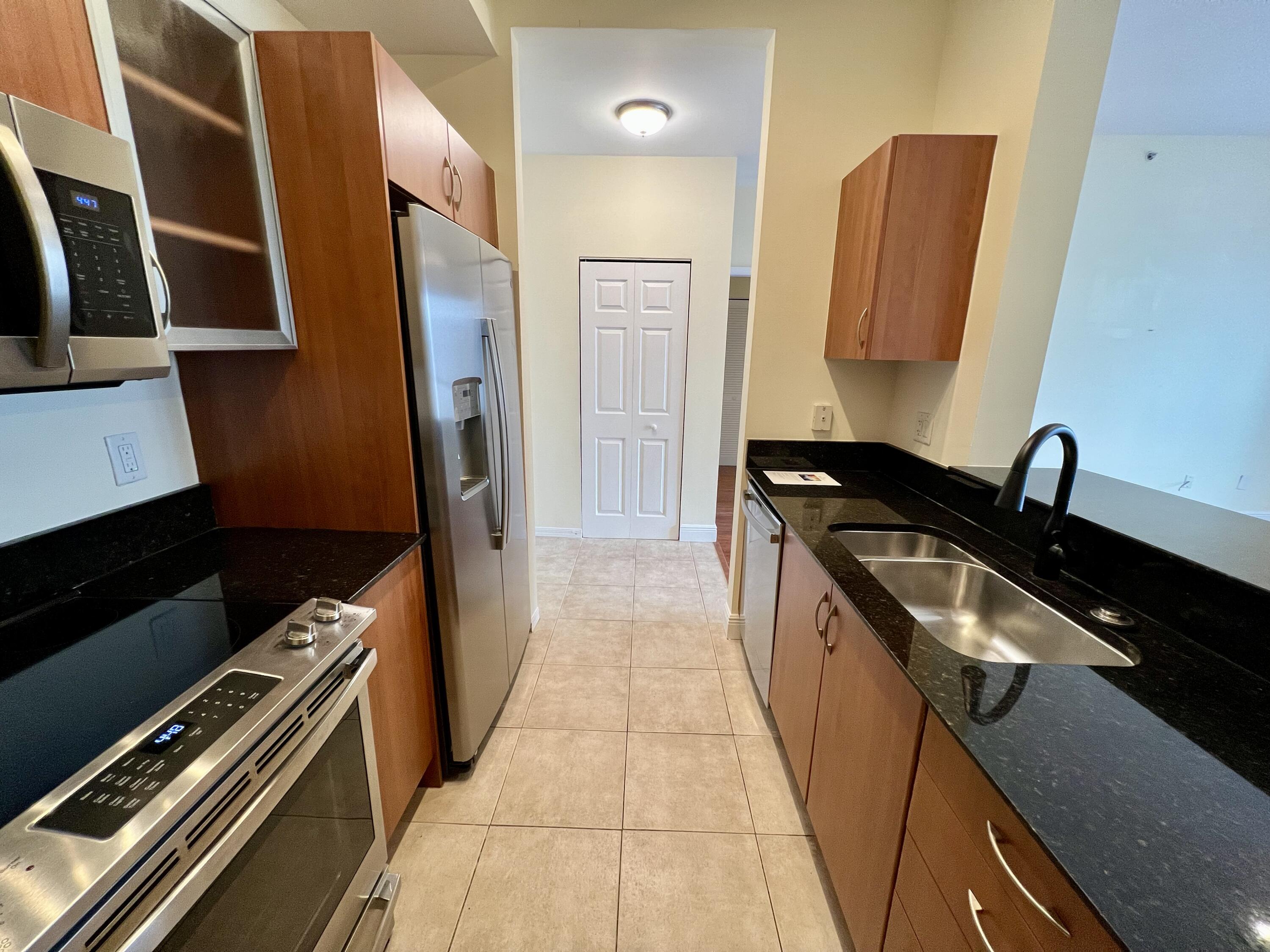 233 South Federal Highway, Unit UPH04 Boca Raton, FL 33432 - Photo 2 of 26 a kitchen with granite countertop a sink and a stove top oven