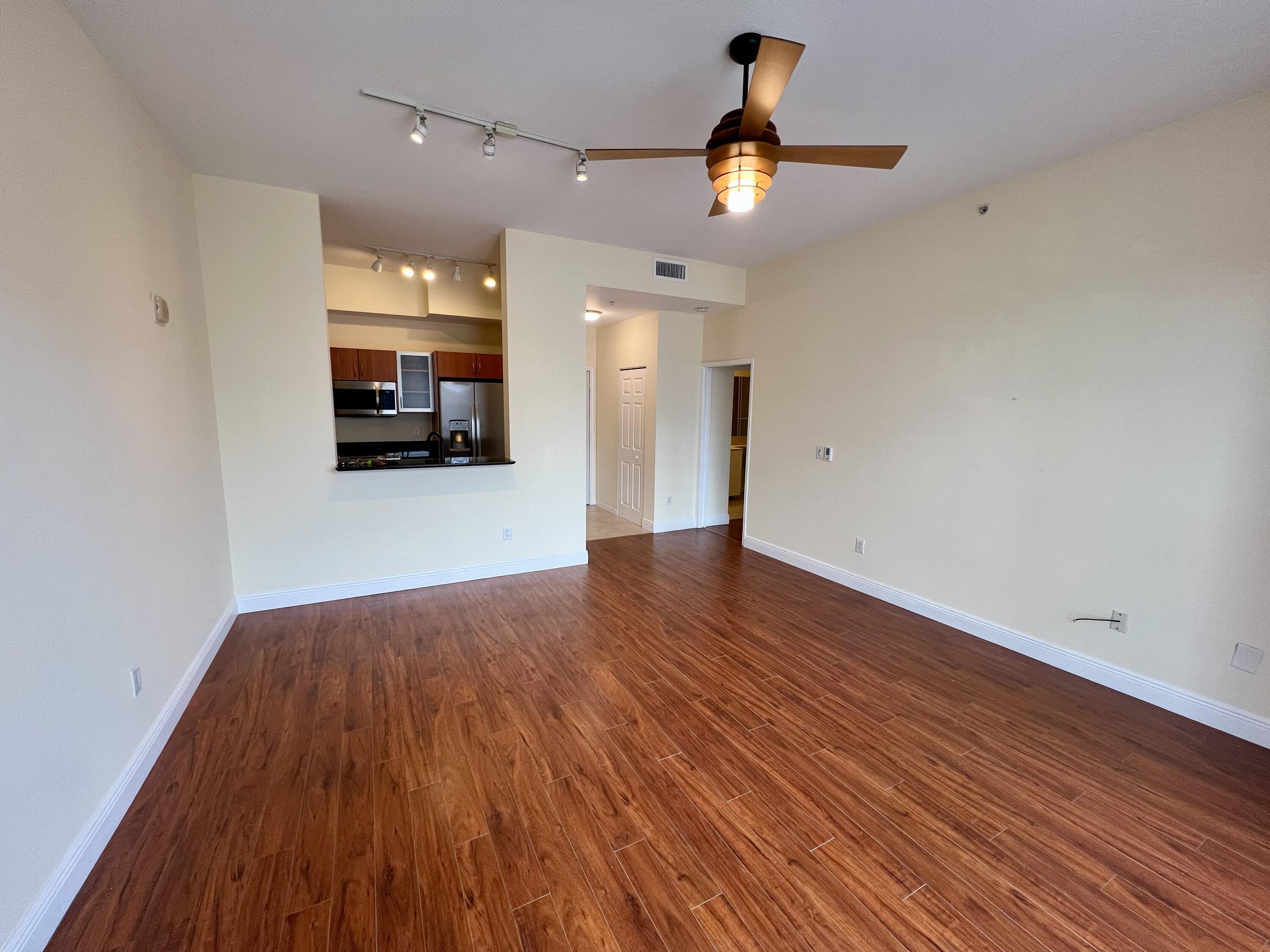 233 South Federal Highway, Unit UPH04 Boca Raton, FL 33432 - Photo 7 of 26 a view of a livingroom with a ceiling fan and wooden floor