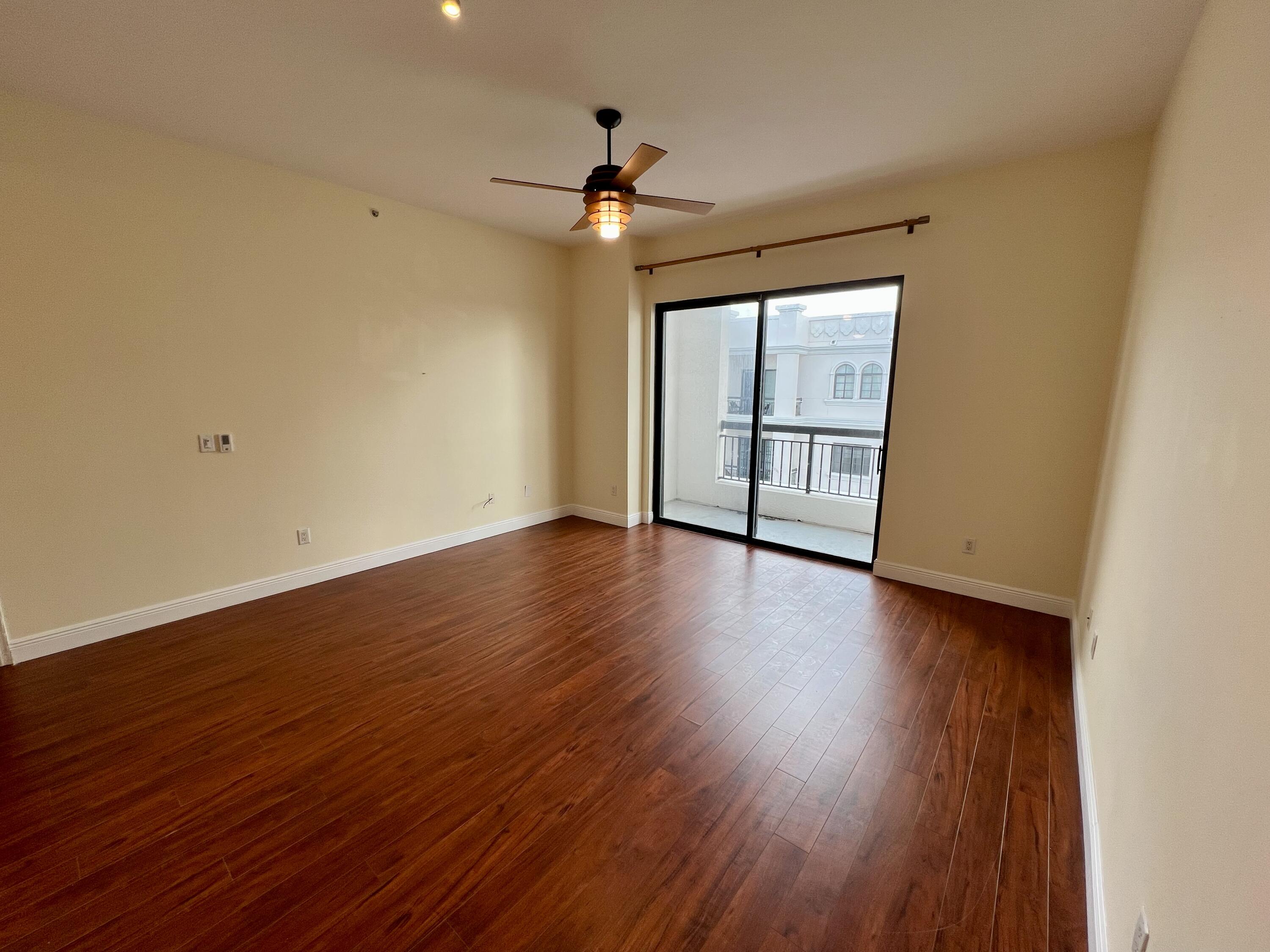 233 South Federal Highway, Unit UPH04 Boca Raton, FL 33432 - Photo 8 of 26 a view of room with wooden floor and ceiling fan