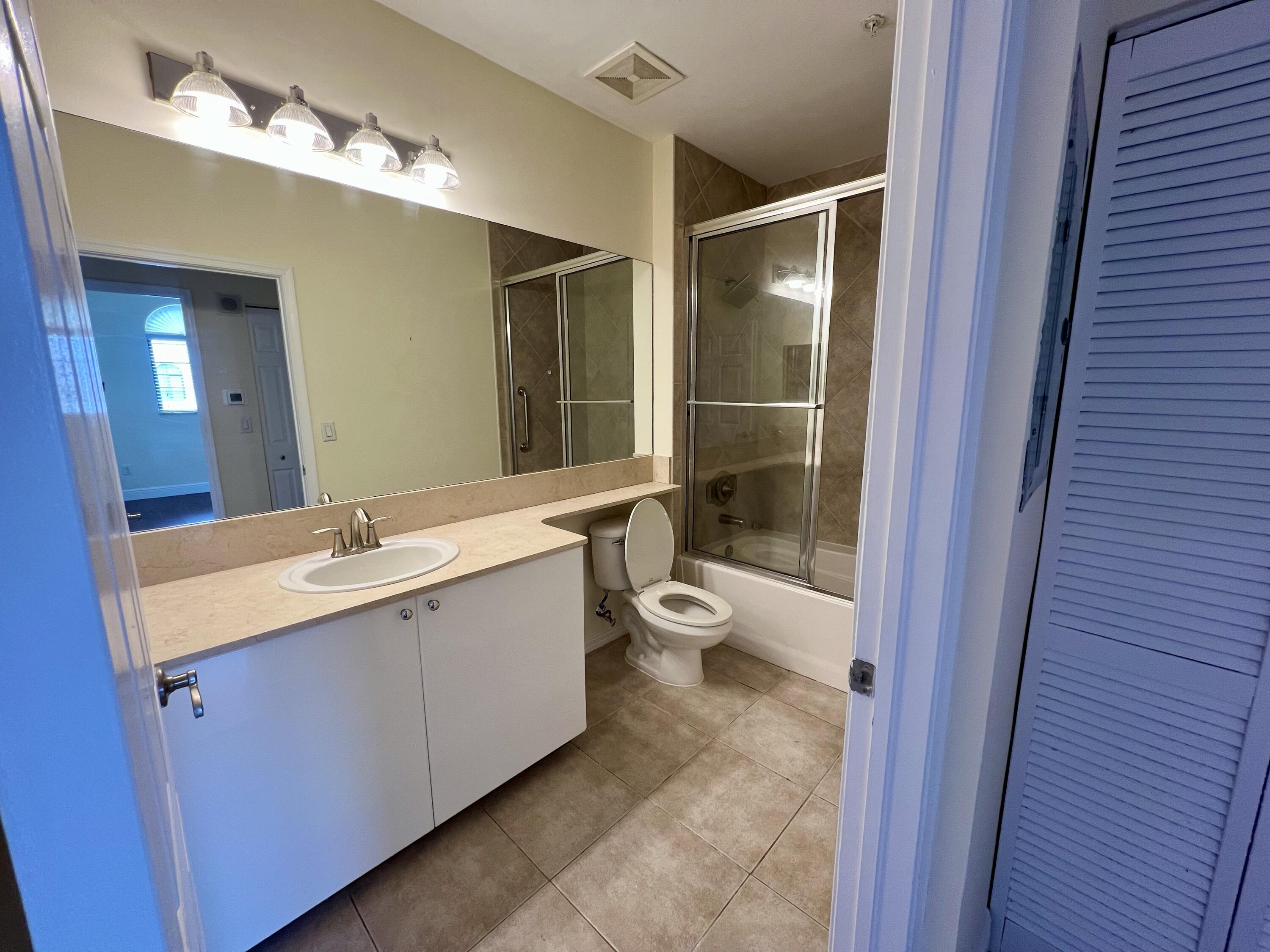 233 South Federal Highway, Unit UPH04 Boca Raton, FL 33432 - Photo 9 of 26 a bathroom with a double vanity sink toilet mirror and bathtub