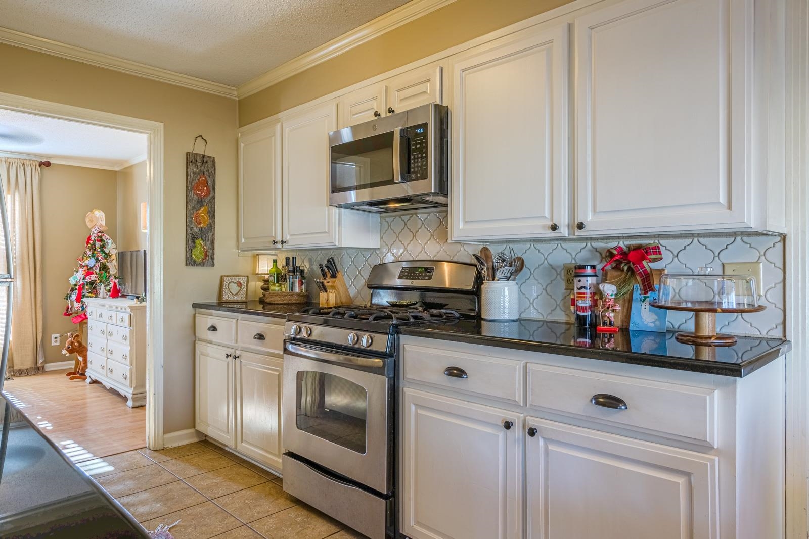 704 Irene Circle Covington, TN 38019 - Photo 11 of 31 a kitchen with stainless steel appliances granite countertop a stove a microwave and cabinets