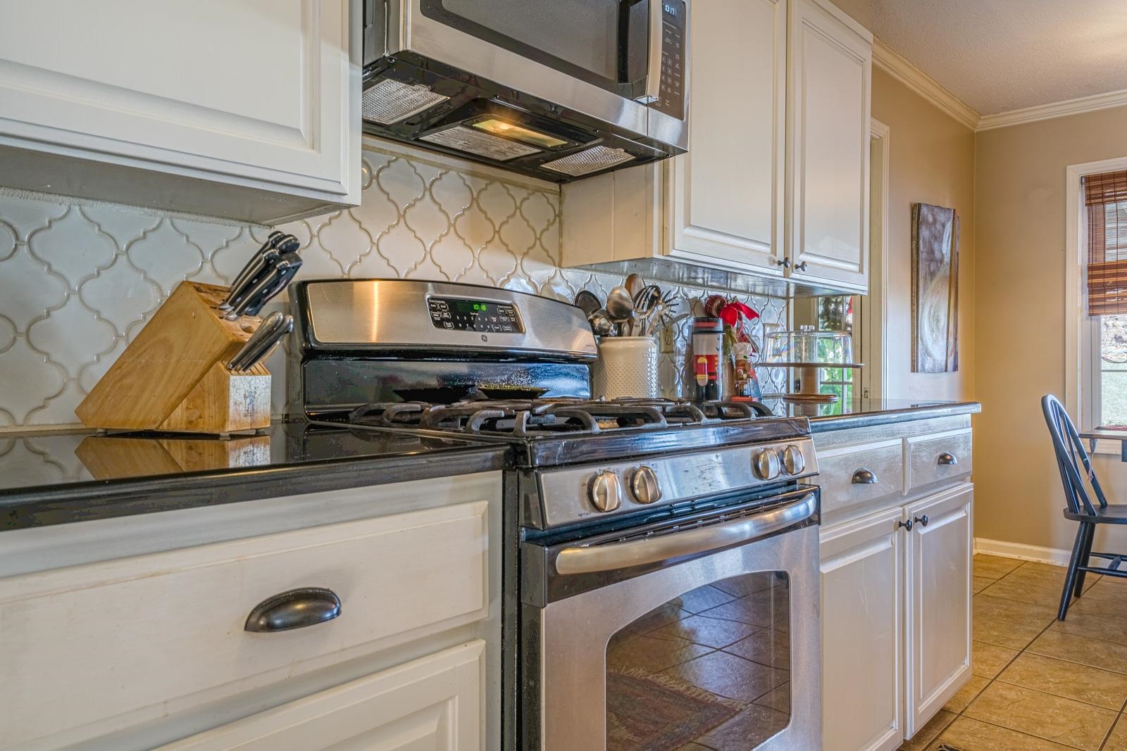 704 Irene Circle Covington, TN 38019 - Photo 12 of 31 a kitchen with stainless steel appliances granite countertop a stove and a microwave