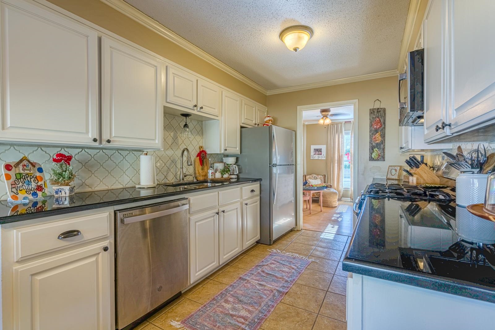 704 Irene Circle Covington, TN 38019 - Photo 10 of 31 a kitchen with stainless steel appliances granite countertop a sink dishwasher stove and refrigerator