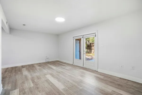 a bedroom with a bed dresser and wooden floor