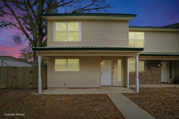 a view of a house with wooden fence