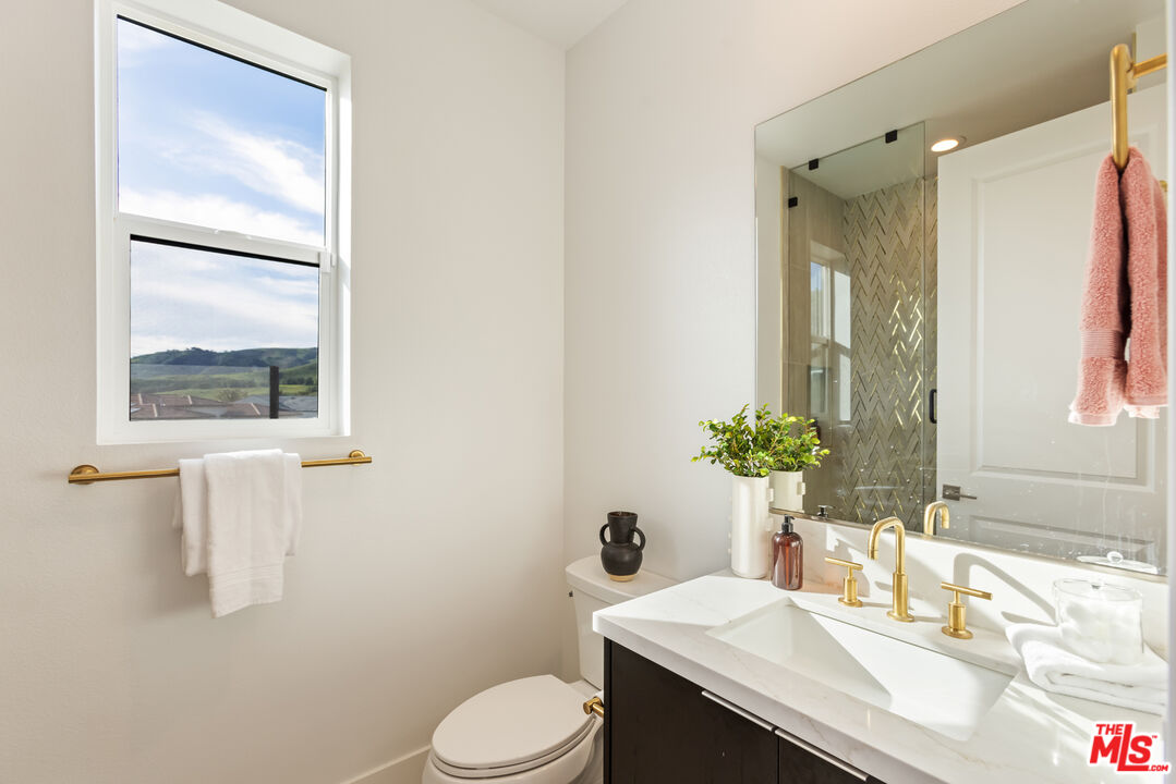 20668 Hummingbird Court Porter Ranch, CA 91326 - Photo 42 of 70 a bathroom with a granite countertop sink toilet and shower