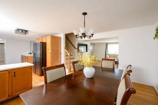 a view of a dining room and livingroom with furniture wooden floor a chandelier