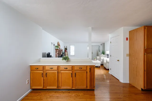 a living room with stainless steel appliances furniture a refrigerator and kitchen view