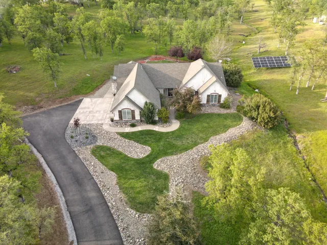 an aerial view of a house with a yard and lake view