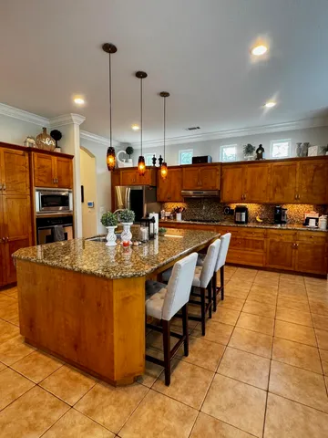 a large kitchen with stainless steel appliances kitchen island granite countertop a large counter top and stove