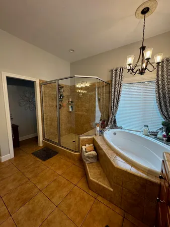 a bedroom with a bed a window and a chandelier