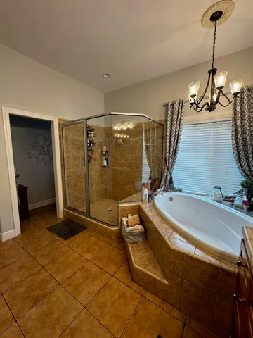 a bedroom with a bed a window and a chandelier