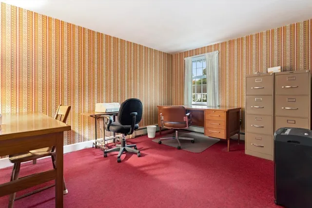 a view of a workspace with furniture and a window