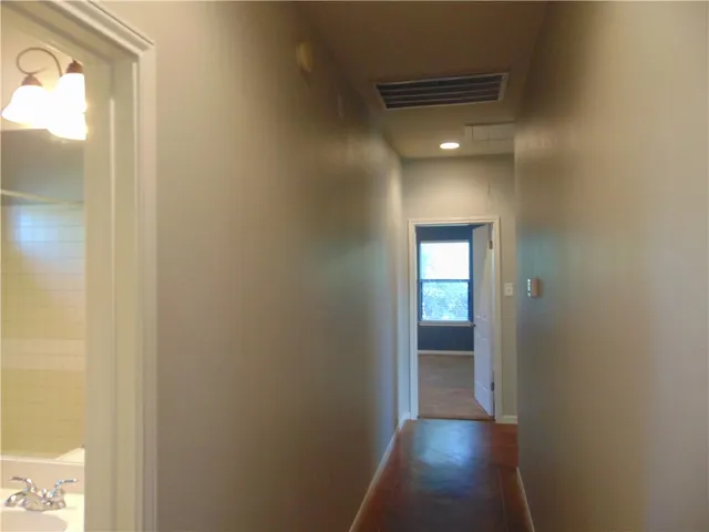 a view of a hallway with wooden floor