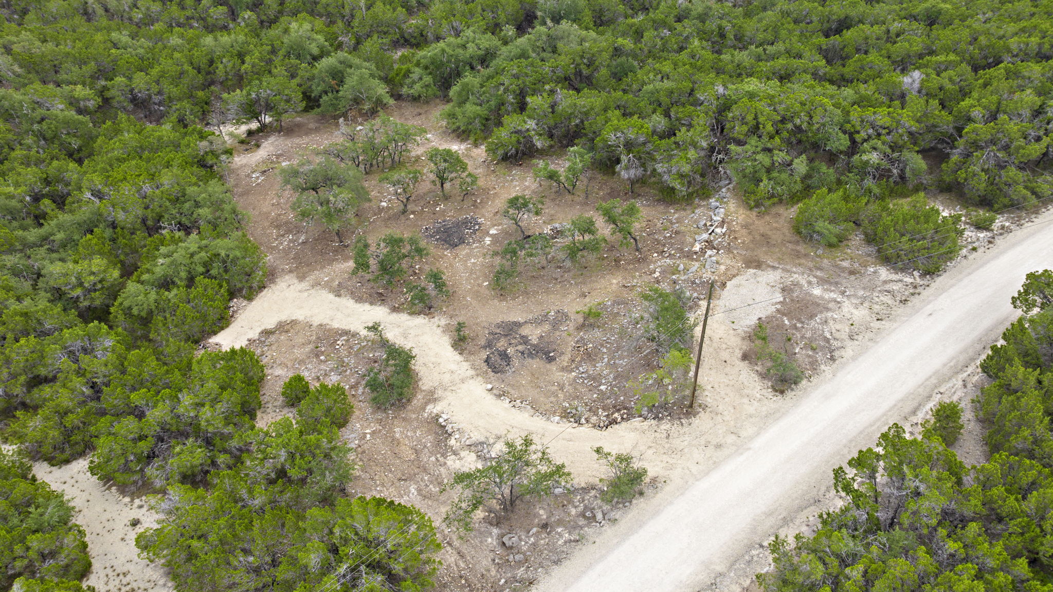 1250 Myers Creek Road Dripping Springs, TX 78620 - Photo 15 of 34 Recent improvements include a new cut entry drive, a wide clearing for a potential home site, and the removal of a natural dam in the dry creek bed.