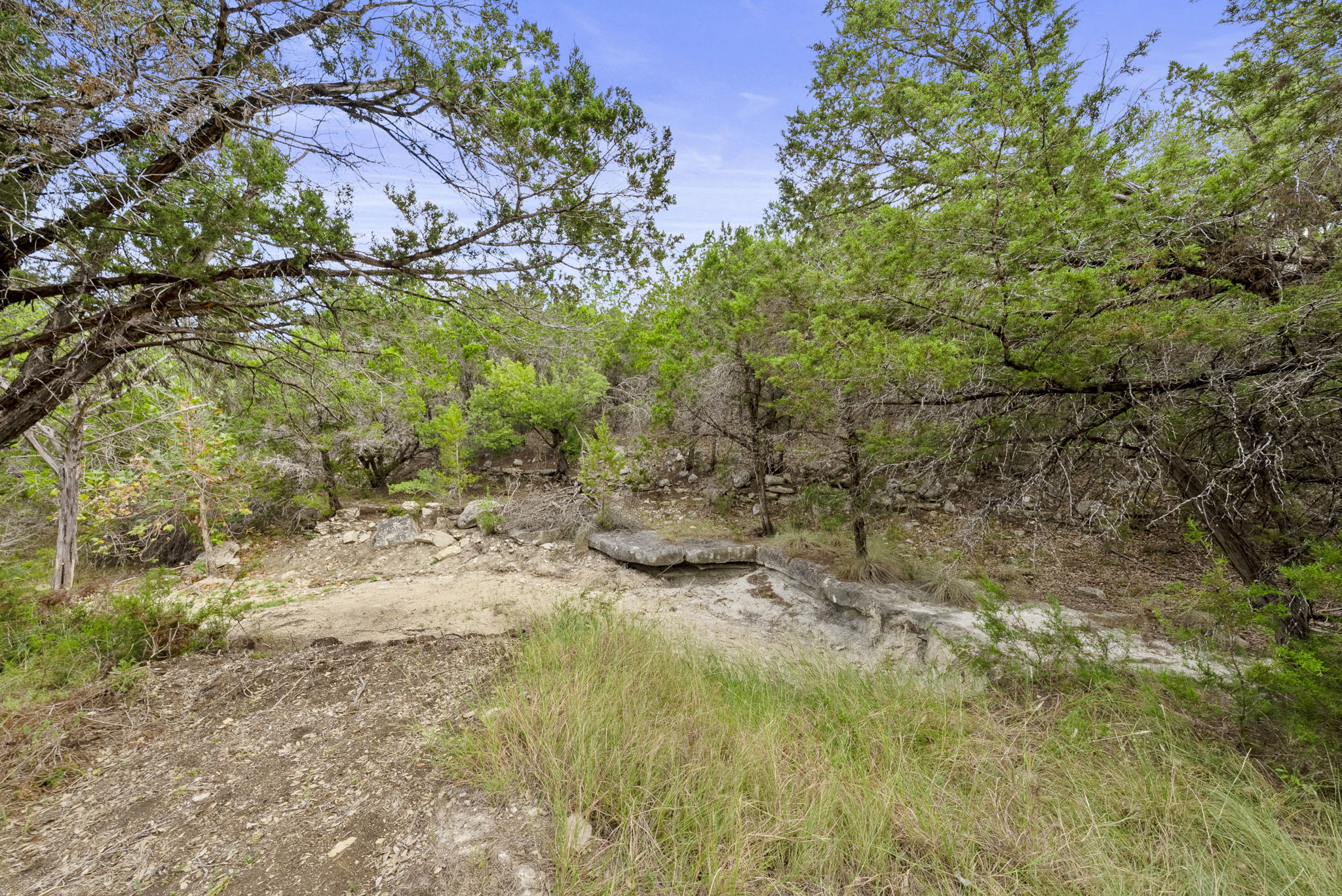 1250 Myers Creek Road Dripping Springs, TX 78620 - Photo 20 of 34 Recent improvements include a new cut entry drive, a wide clearing for a potential home site, and the removal of a natural dam in the dry creek bed.