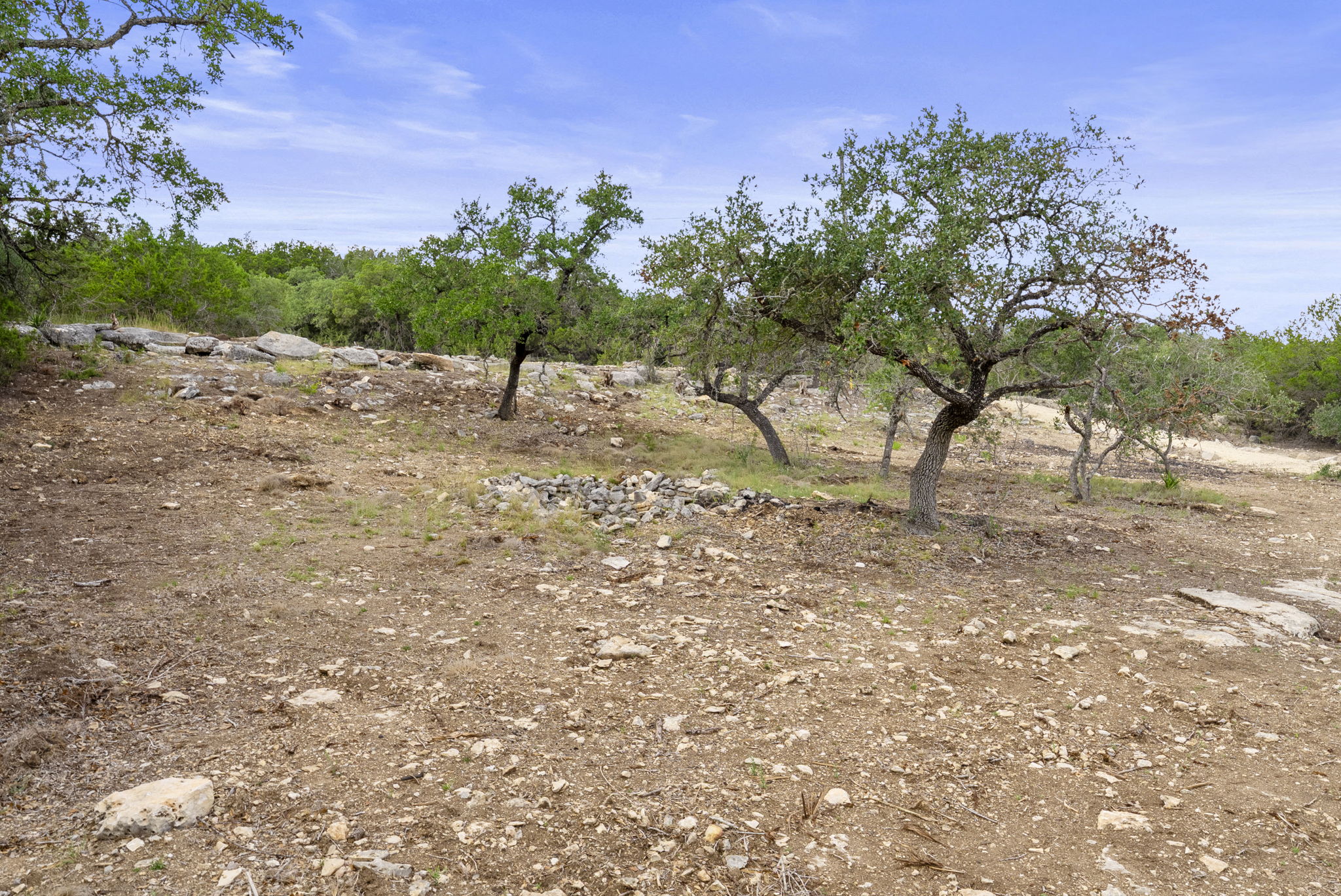 1250 Myers Creek Road Dripping Springs, TX 78620 - Photo 21 of 34 Recent improvements include a new cut entry drive, a wide clearing for a potential home site, and the removal of a natural dam in the dry creek bed.