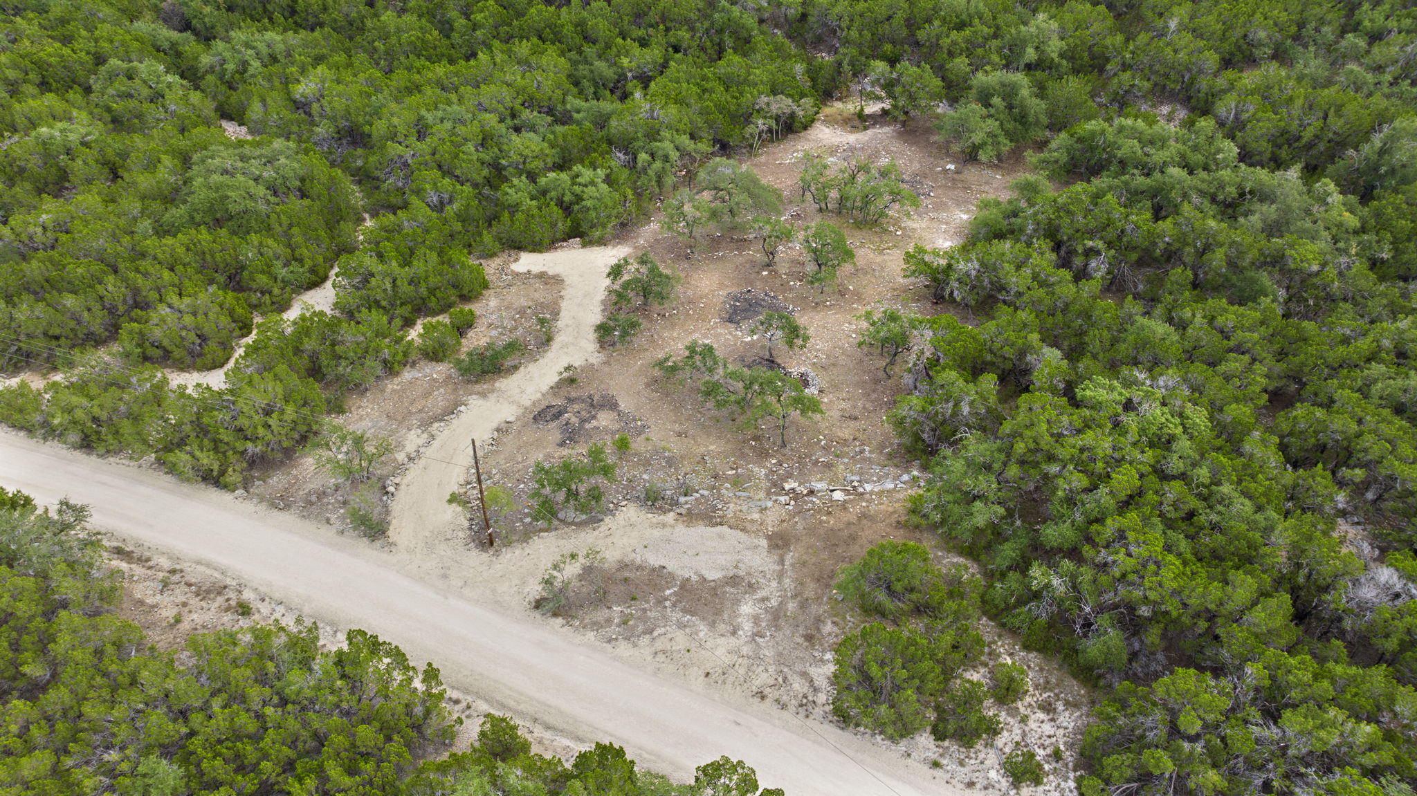 1250 Myers Creek Road Dripping Springs, TX 78620 - Photo 5 of 34 Recent improvements include a new cut entry drive, a wide clearing for a potential home site, and the removal of a natural dam in the dry creek bed.