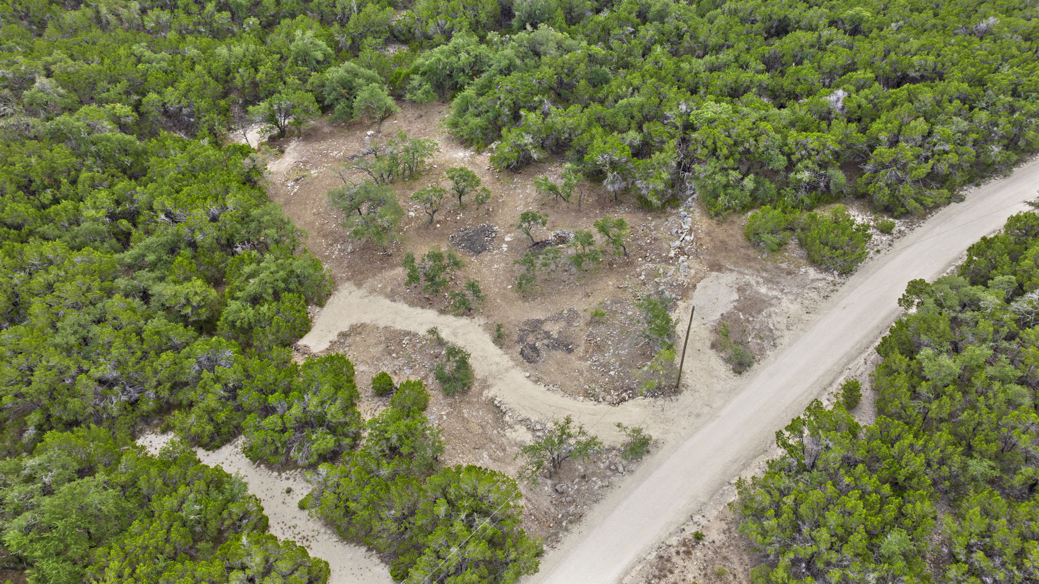 1250 Myers Creek Road Dripping Springs, TX 78620 - Photo 6 of 34 Recent improvements include a new cut entry drive, a wide clearing for a potential home site, and the removal of a natural dam in the dry creek bed.