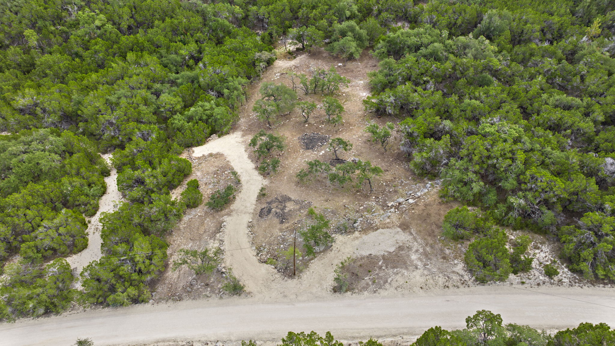 1250 Myers Creek Road Dripping Springs, TX 78620 - Photo 7 of 34 Recent improvements include a new cut entry drive, a wide clearing for a potential home site, and the removal of a natural dam in the dry creek bed.