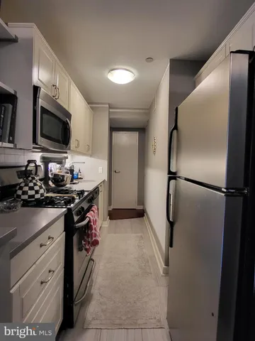 a kitchen with stainless steel appliances a refrigerator sink and microwave