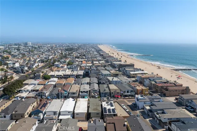 an aerial view of a city with ocean view in back