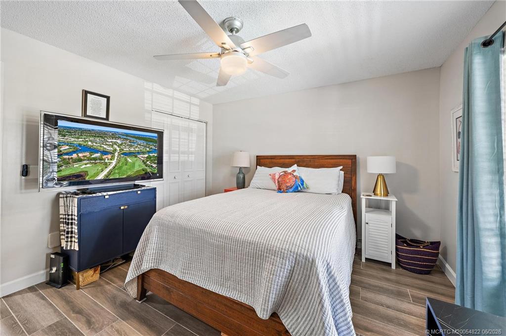 1862 Southwest Palm City Road, Unit 203 Stuart, FL 34994 - Photo 26 of 39 a bedroom with a bed and a flat screen tv