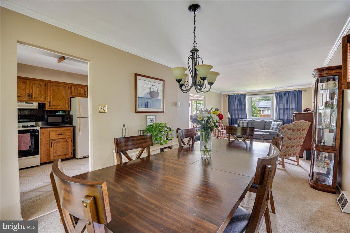 519 Bancroft Road Cherry Hill, NJ 08034 - Photo 12 of 28 a view of a dining room and livingroom with furniture wooden floor a chandelier