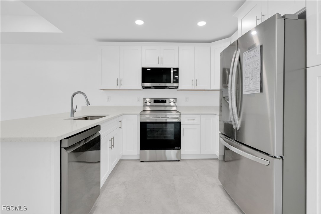 2510 Park Road Lehigh Acres, FL 33971 - Photo 8 of 37 a kitchen with stainless steel appliances a refrigerator stove and microwave