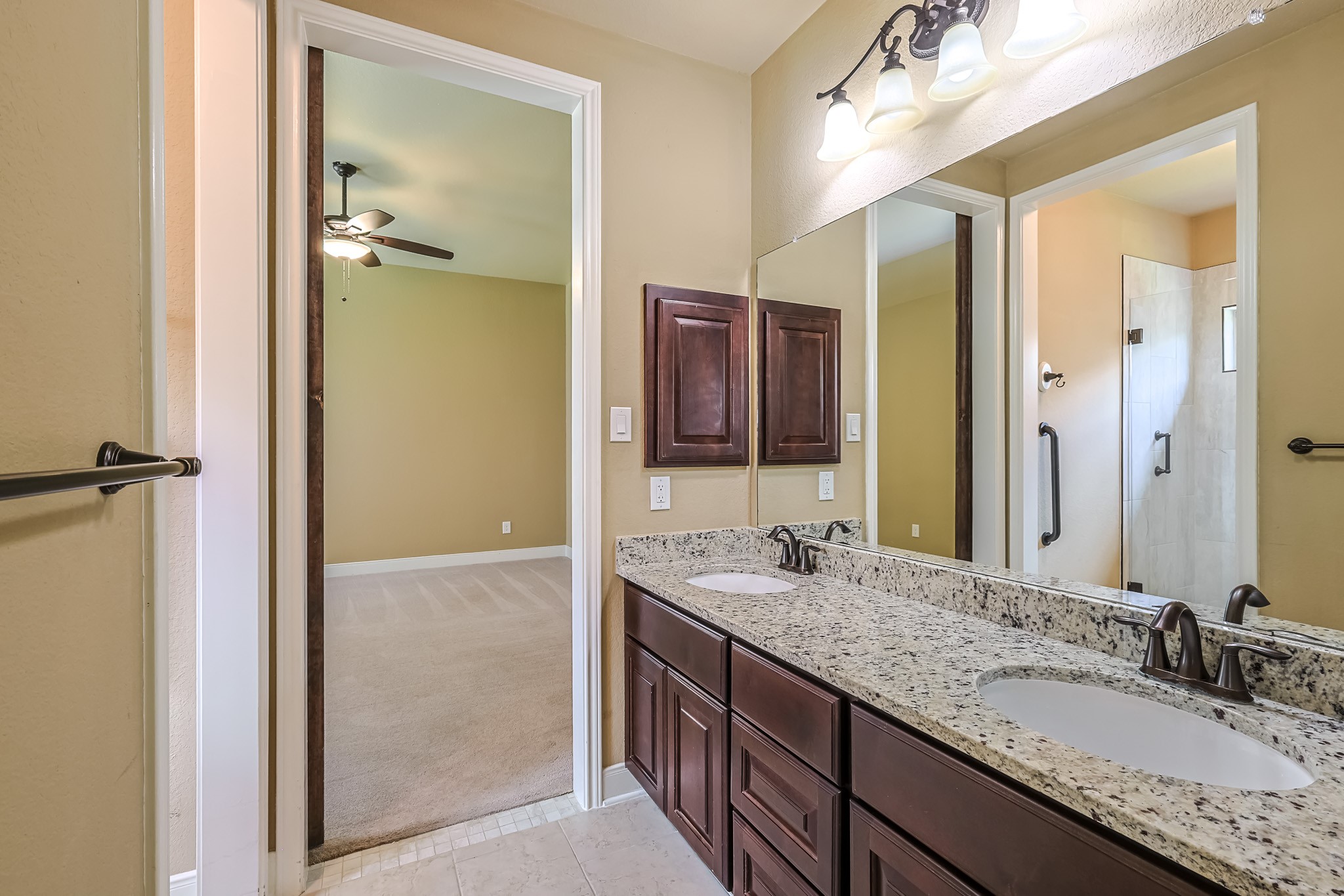 515 Mill Creek Road Pinehurst, TX 77362 - Photo 33 of 48 This photo showcases bathroom with a double sink vanity featuring granite countertops and dark wood cabinets.