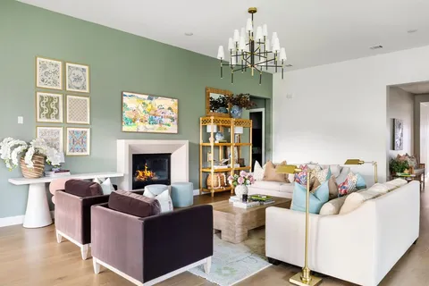 a living room with furniture a chandelier and a fireplace