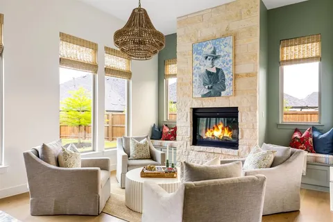 a living room with furniture a chandelier and a fireplace