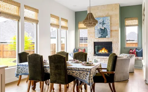 a dining room with furniture a fireplace and wooden floor