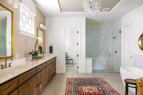 a bathroom with a double vanity sink mirror and bathtub