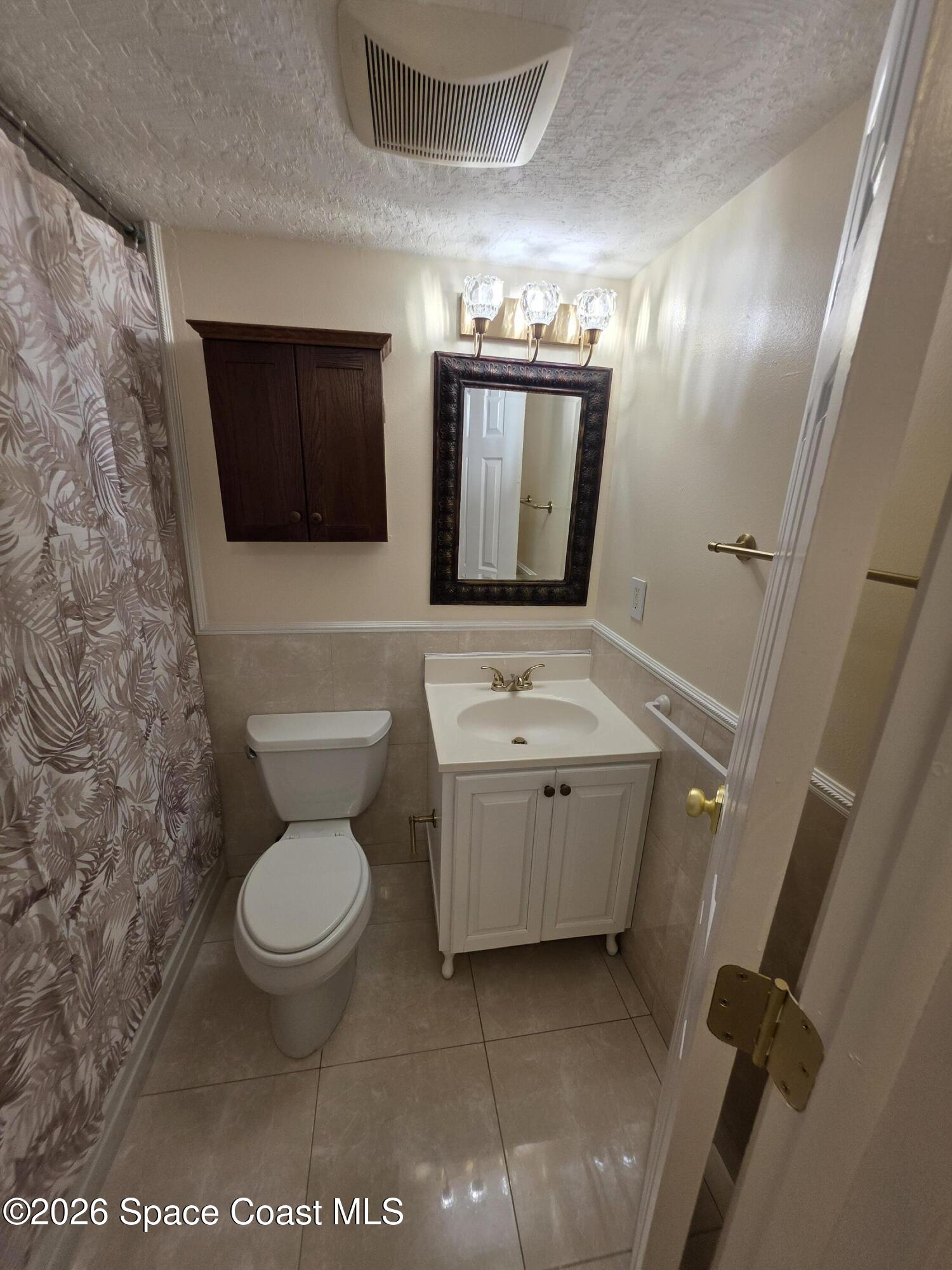 189 Cambridge Lane Melbourne, FL 32935 - Photo 11 of 14 a bathroom with a toilet sink and mirror