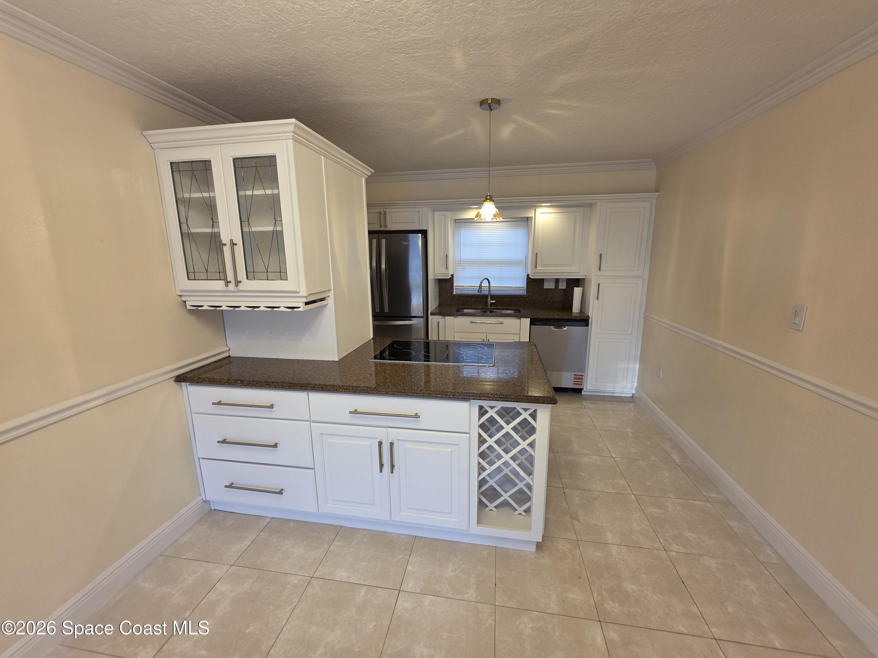 189 Cambridge Lane Melbourne, FL 32935 - Photo 4 of 14 a kitchen with stainless steel appliances a sink stove and cabinets