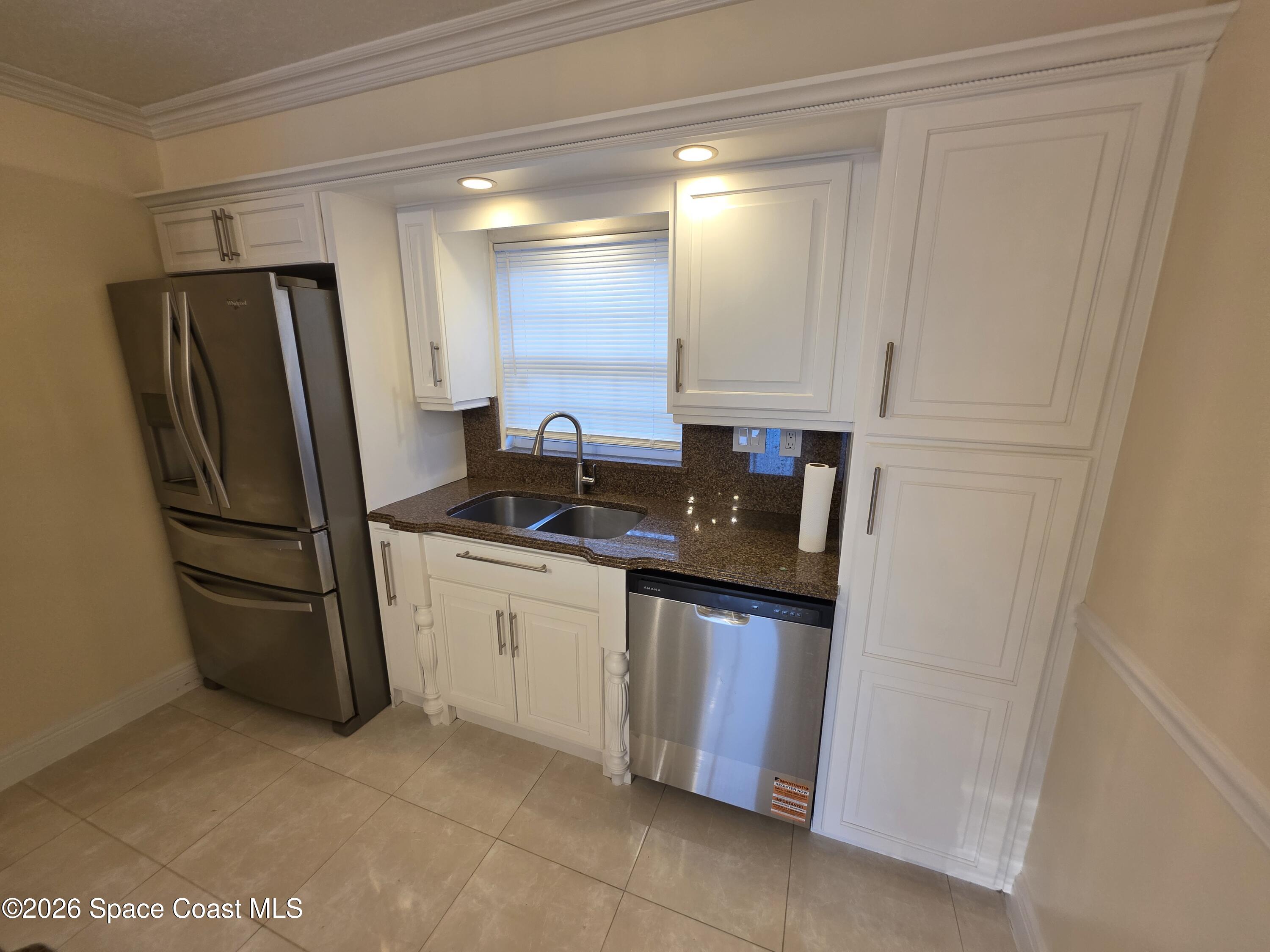 189 Cambridge Lane Melbourne, FL 32935 - Photo 5 of 14 a kitchen with stainless steel appliances granite countertop a refrigerator and a sink