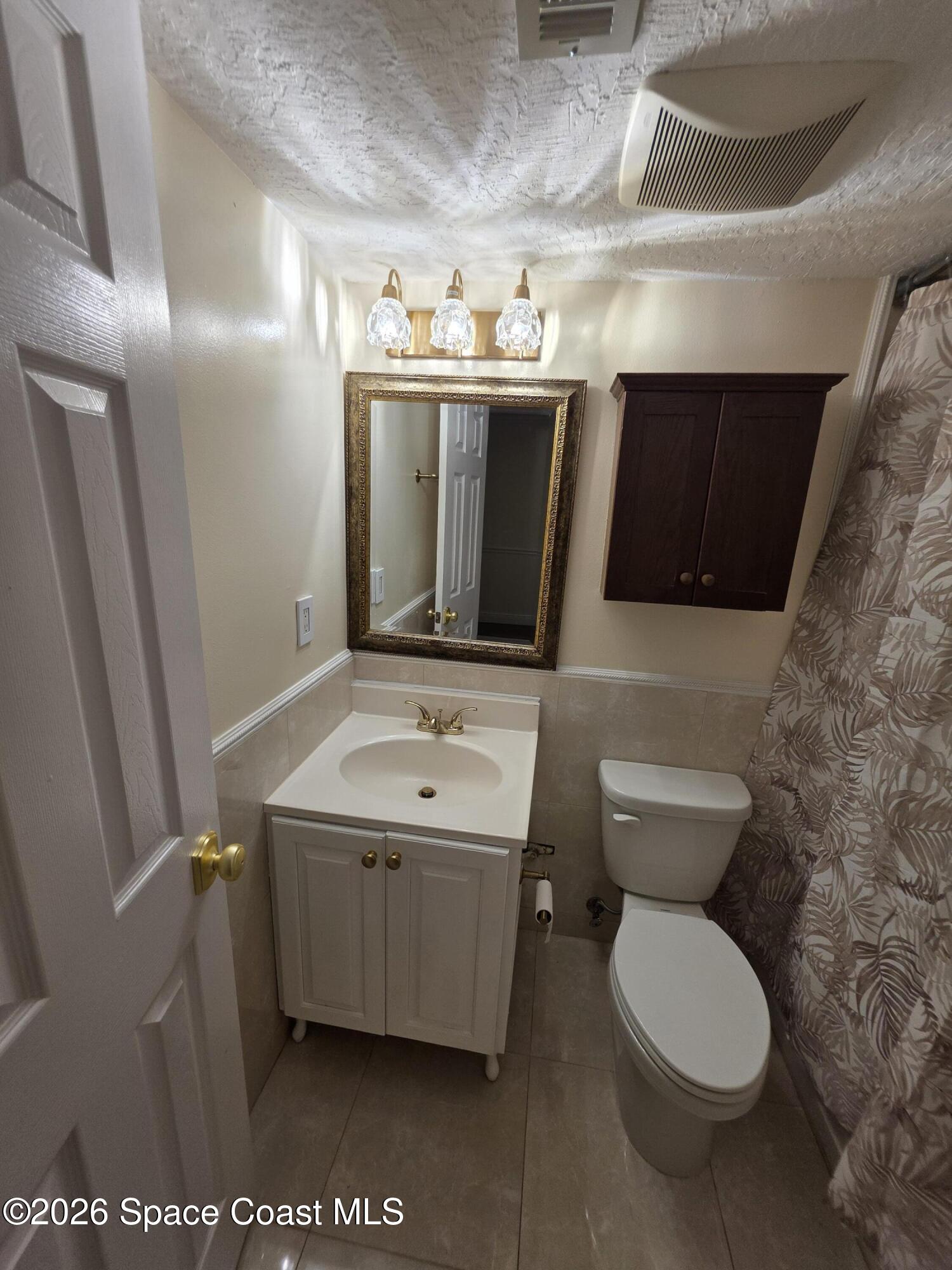 189 Cambridge Lane Melbourne, FL 32935 - Photo 7 of 14 a bathroom with a toilet sink and mirror