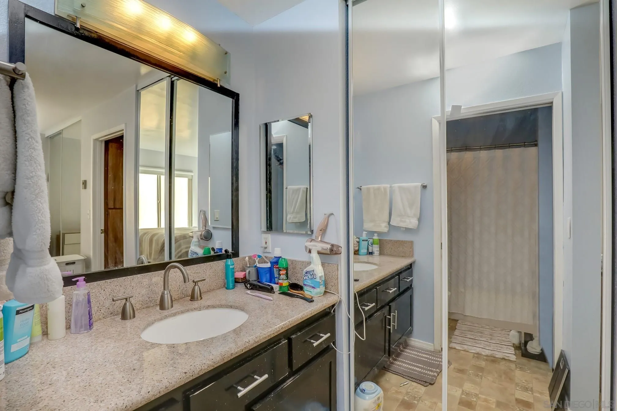5910 Rancho Mission Road, Unit 40 San Diego, CA 92108 - Photo 13 of 17 a bathroom with a granite countertop sink and a mirror