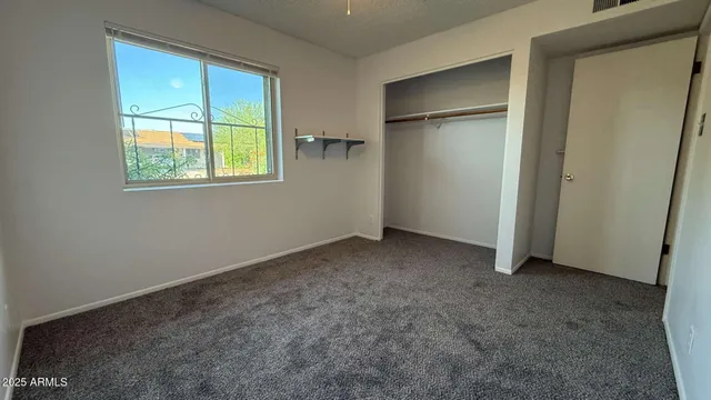an empty room with windows and closet