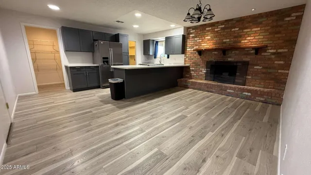 a open kitchen with kitchen island a sink dishwasher a stove and a refrigerator with wooden floor