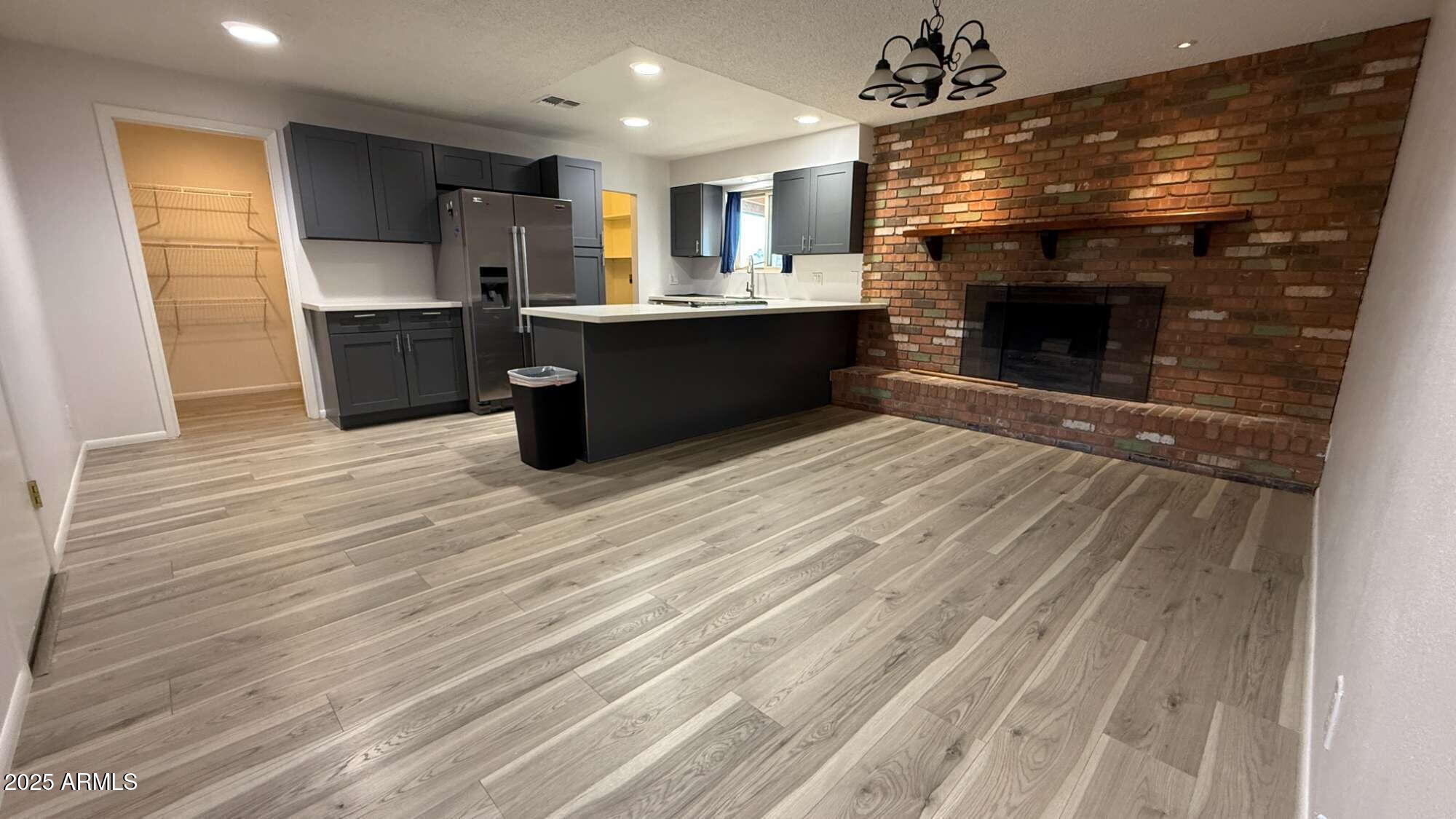3707 West Alice Avenue Phoenix, AZ 85051 - Photo 6 of 27 a open kitchen with kitchen island a sink dishwasher a stove and a refrigerator with wooden floor