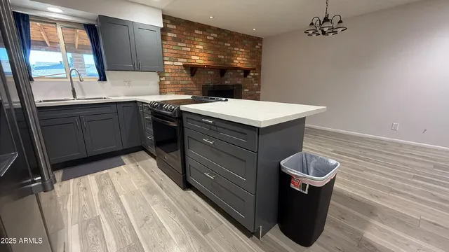 a kitchen with a sink and wooden floor