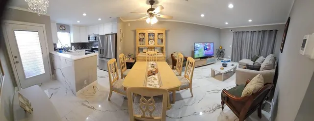 a living room with furniture a fireplace and kitchen view