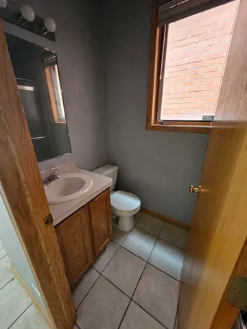 a bathroom with a sink a toilet a window and vanity